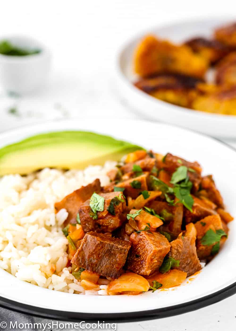 easy cooked Beef tongue in tomato sauce in a plate with  white rice and avocado