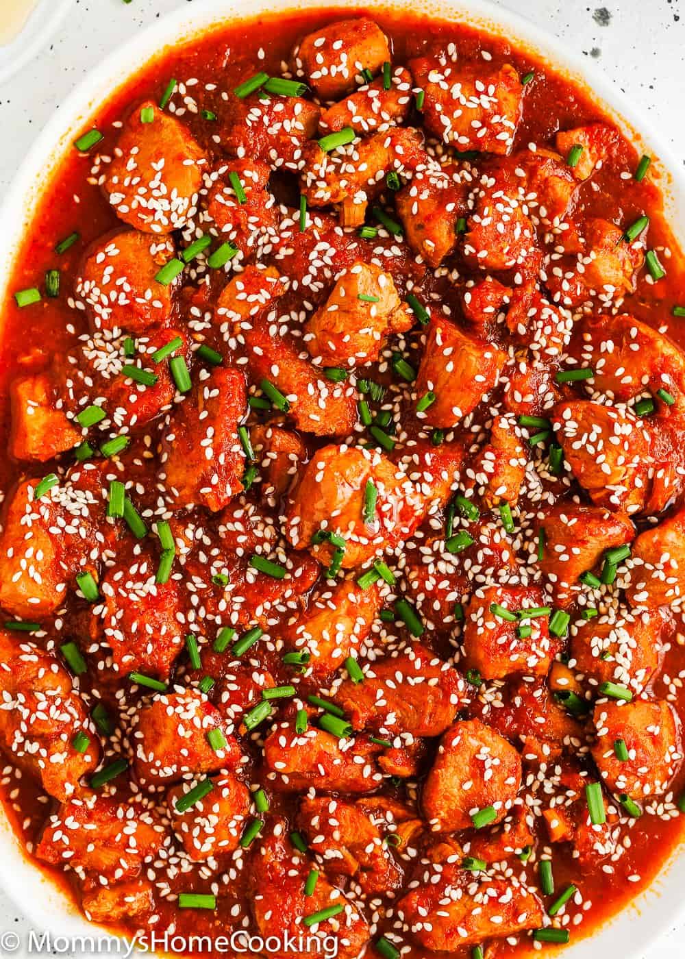 Instant Pot Korean Kimchi Chicken in a white plate with sesame seed and chives