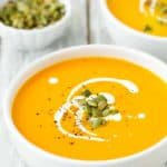 Easy Instant Pot Pumpkin Soup in a bowl with cream and roasted pumpkin seeds