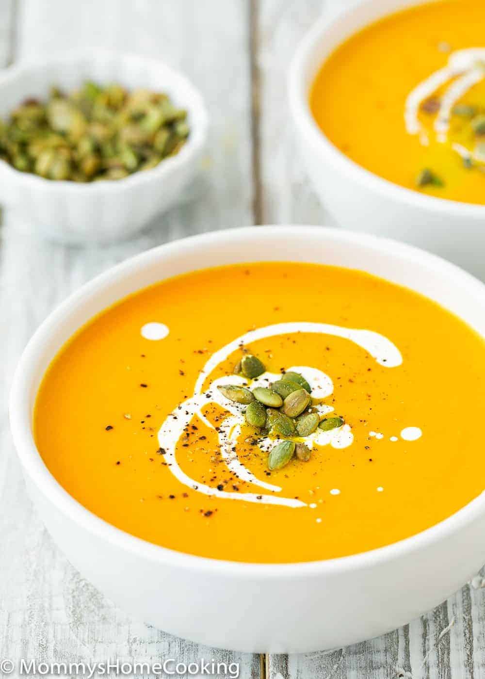 Easy Instant Pot Pumpkin Soup in a bowl with cream and roasted pumpkin seeds