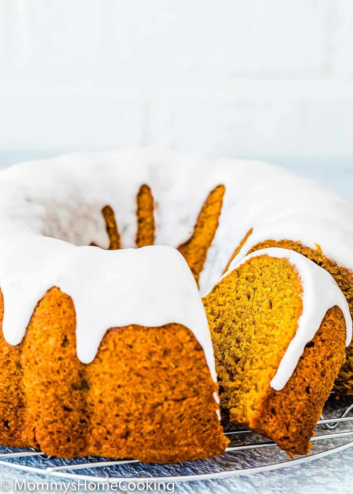 sliced Eggless Pumpkin Cake with glaze over a cooling rack