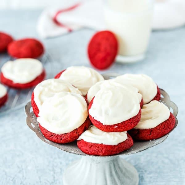 eggless red velvet cookies with cream cheese frosting on a cake stand
