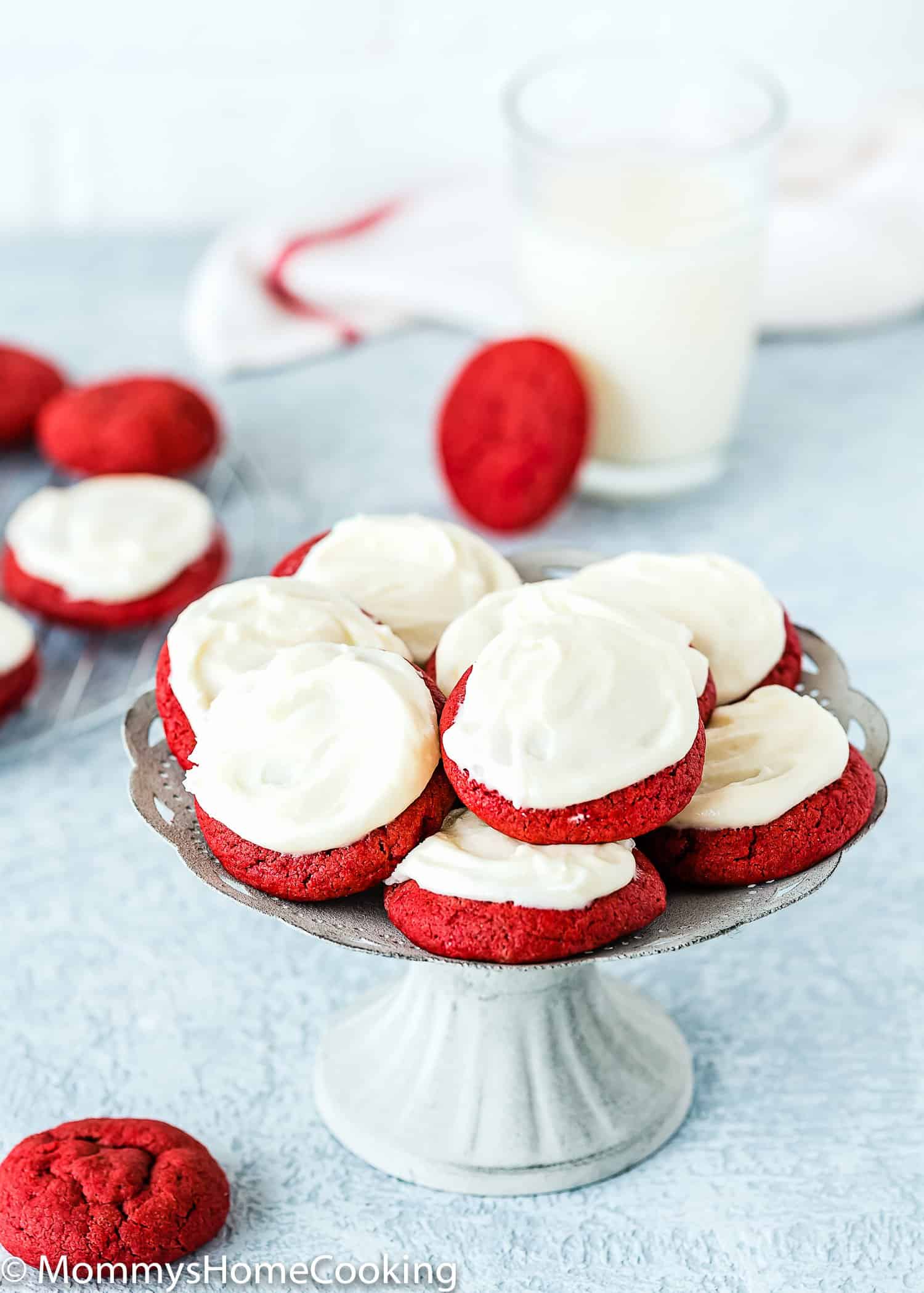 eggless red velvet cookies with cream cheese frosting on a cake stand