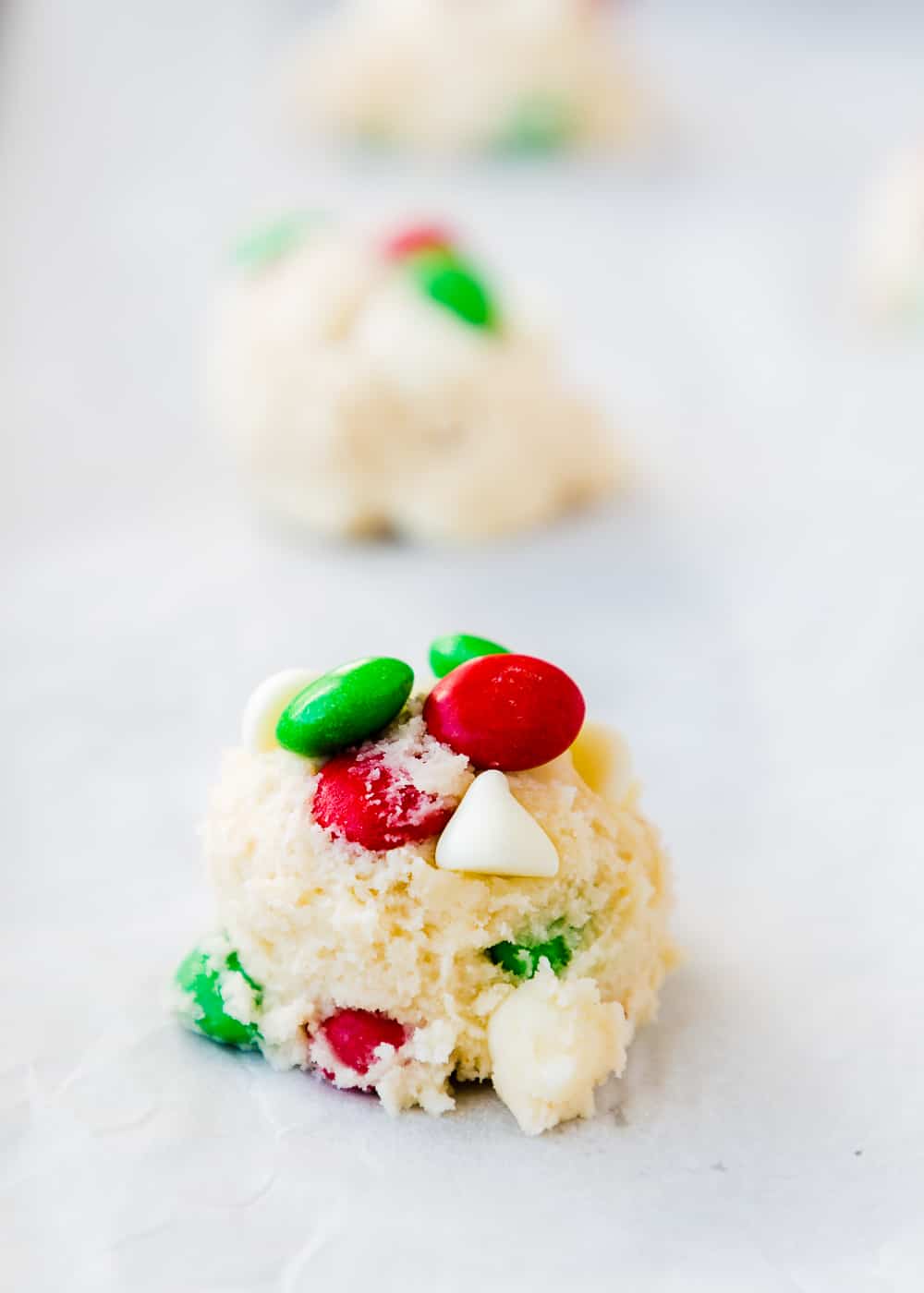egg-free cookie dough ball with m&ms and chocolate chips on top. 