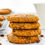 stack of four Dairy-Free & Egg-Free Healthy Breakfast Cookies with a milk jug and more cookies in the background.
