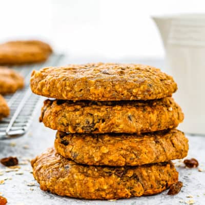 stack of four Dairy-Free & Egg-Free Healthy Breakfast Cookies with a milk jug and more cookies in the background.