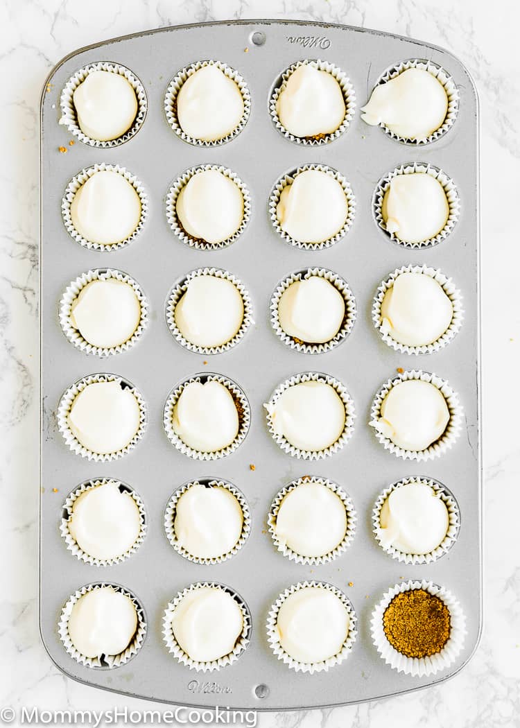 A mini muffin pan filled with mini cheesecakes batter. 