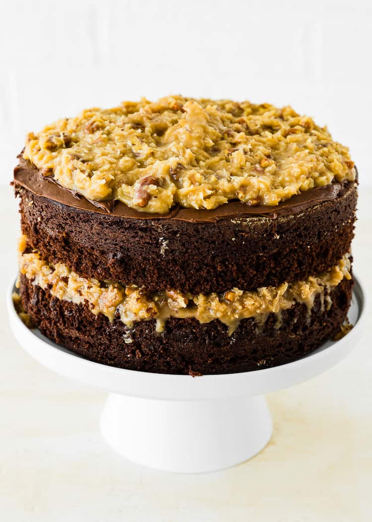 Two layers of egg-free german chocolate cake on a cake stand.