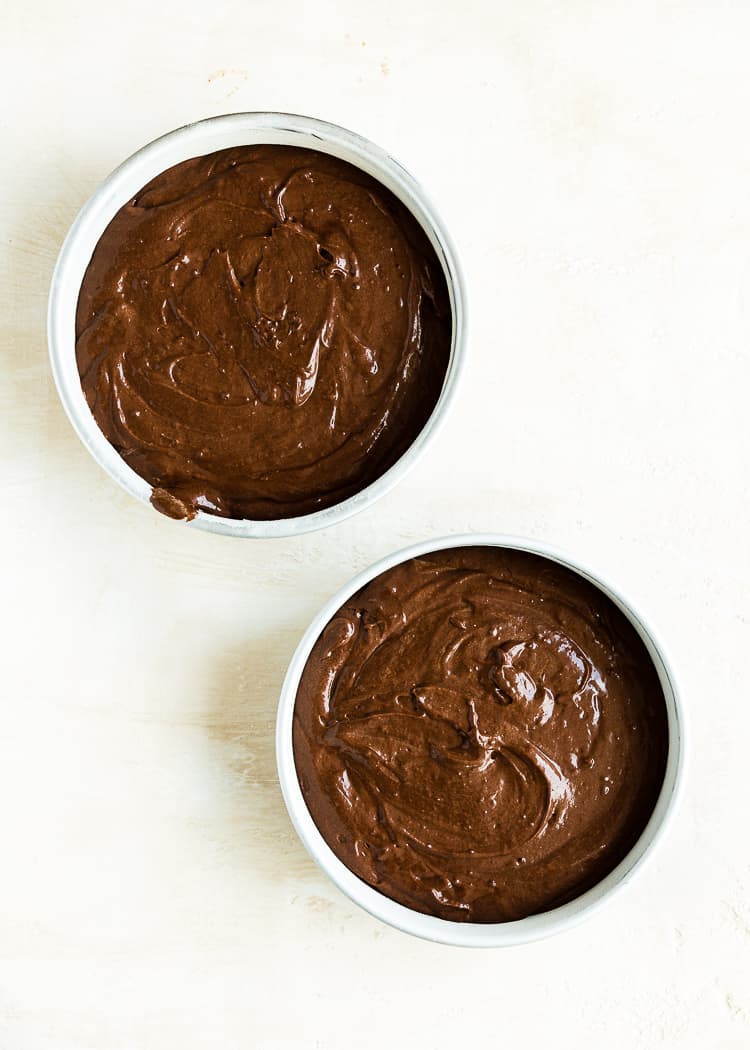 Egg-free chocolate cake batter in two cake pans. 