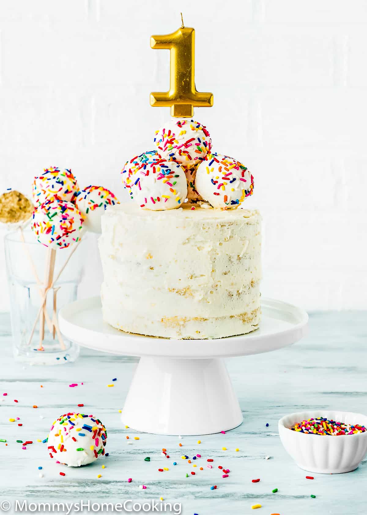 egg-free refined sugar-free smash cake with cake pops on top and a candle