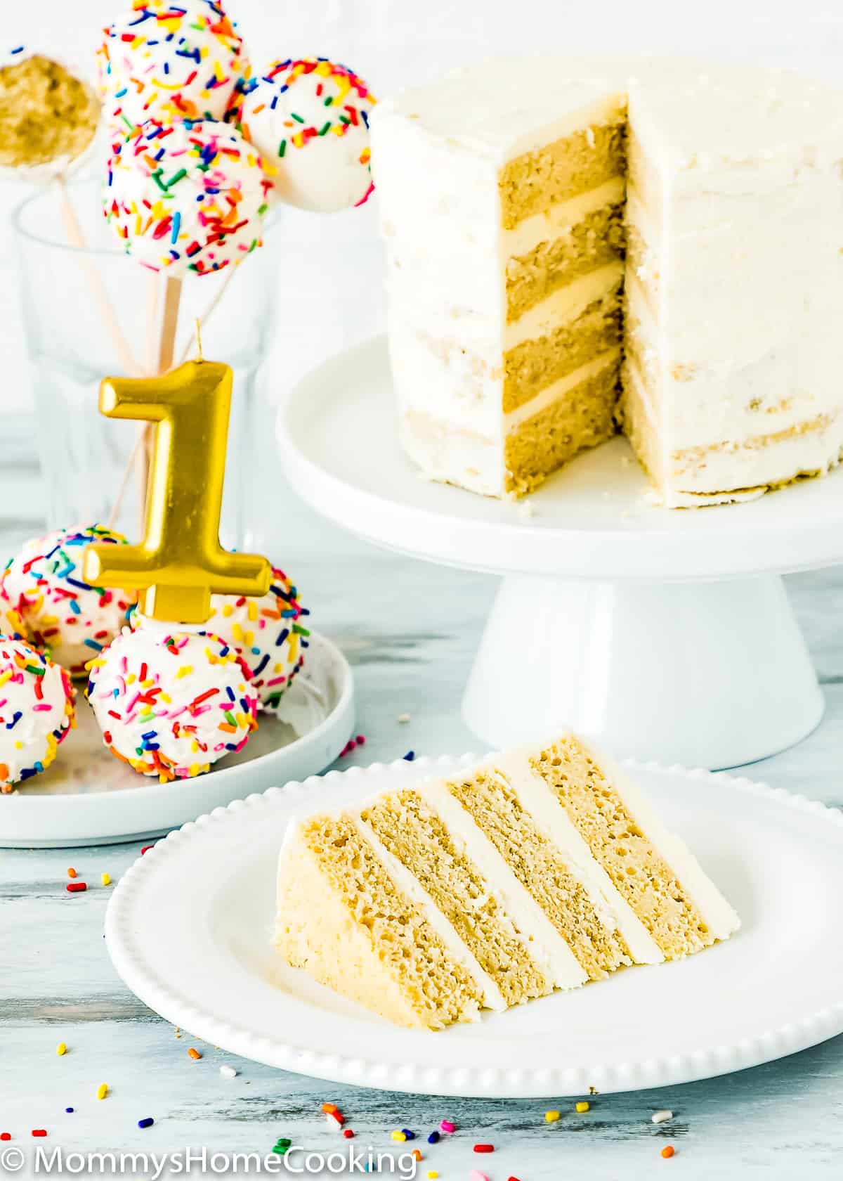 eggless smash cake sliced with cake pops and a candle on the background. 
