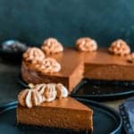 Eggless Chocolate Cheesecake on a plate with the whole cheesecake in the background