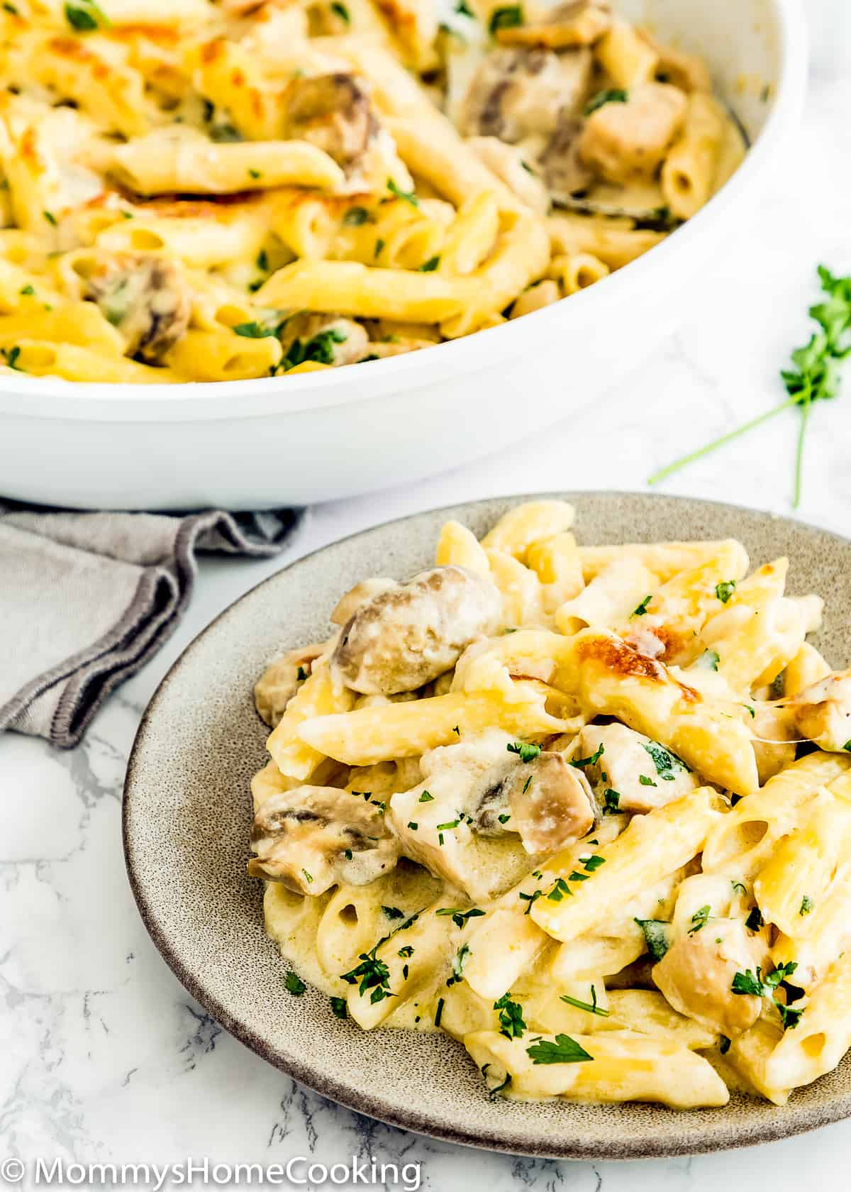 Chicken Tetrazzini on a plate with a skillet in the background