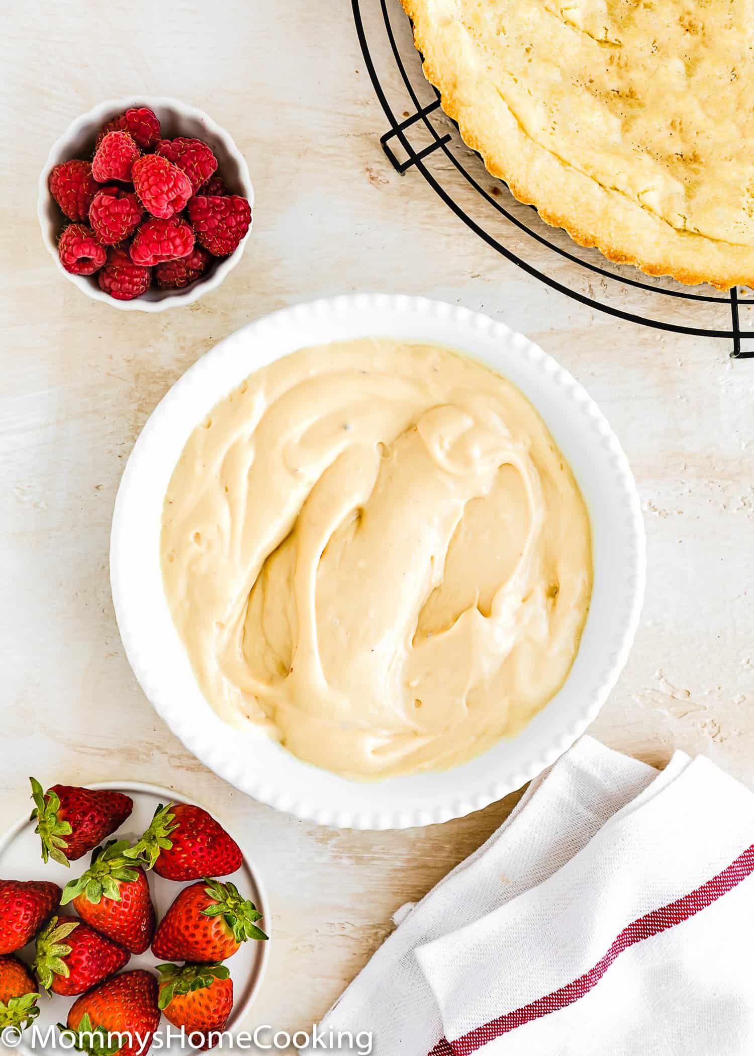 Eggless Pastry Cream in a bowl with fresh berries on the side and a egg-free tart crust.