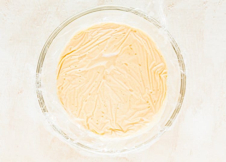 eggless pastry cream in a bowl covered with plastic wrap. 