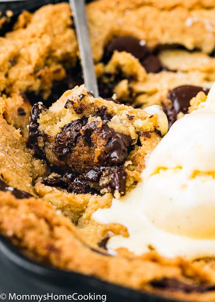 Spoon cutting through an Eggless Chocolate Chip Skillet Cookie