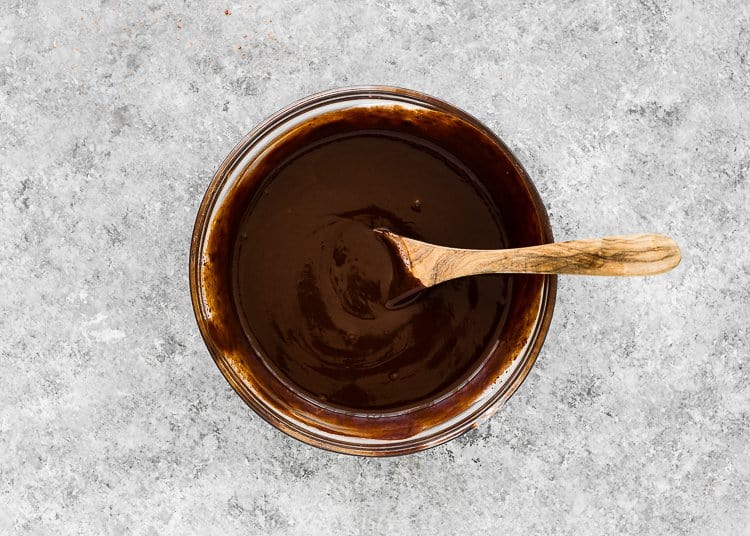 a bowl with chocolate ganache and a wooden spoon. 