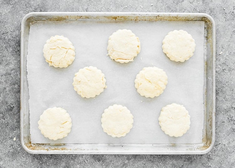 Unbaked eggless homemade biscuits on a baking tray.