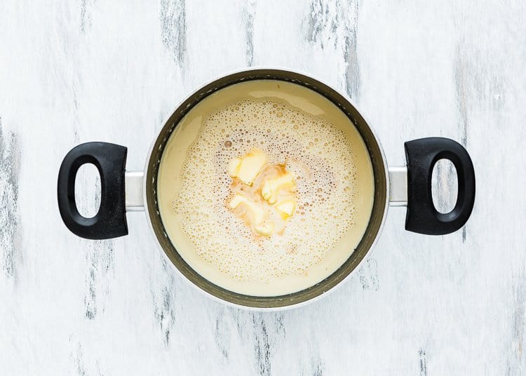 egg-free creme brulee mixture in a saucepan with a whisk with butter and vanilla.