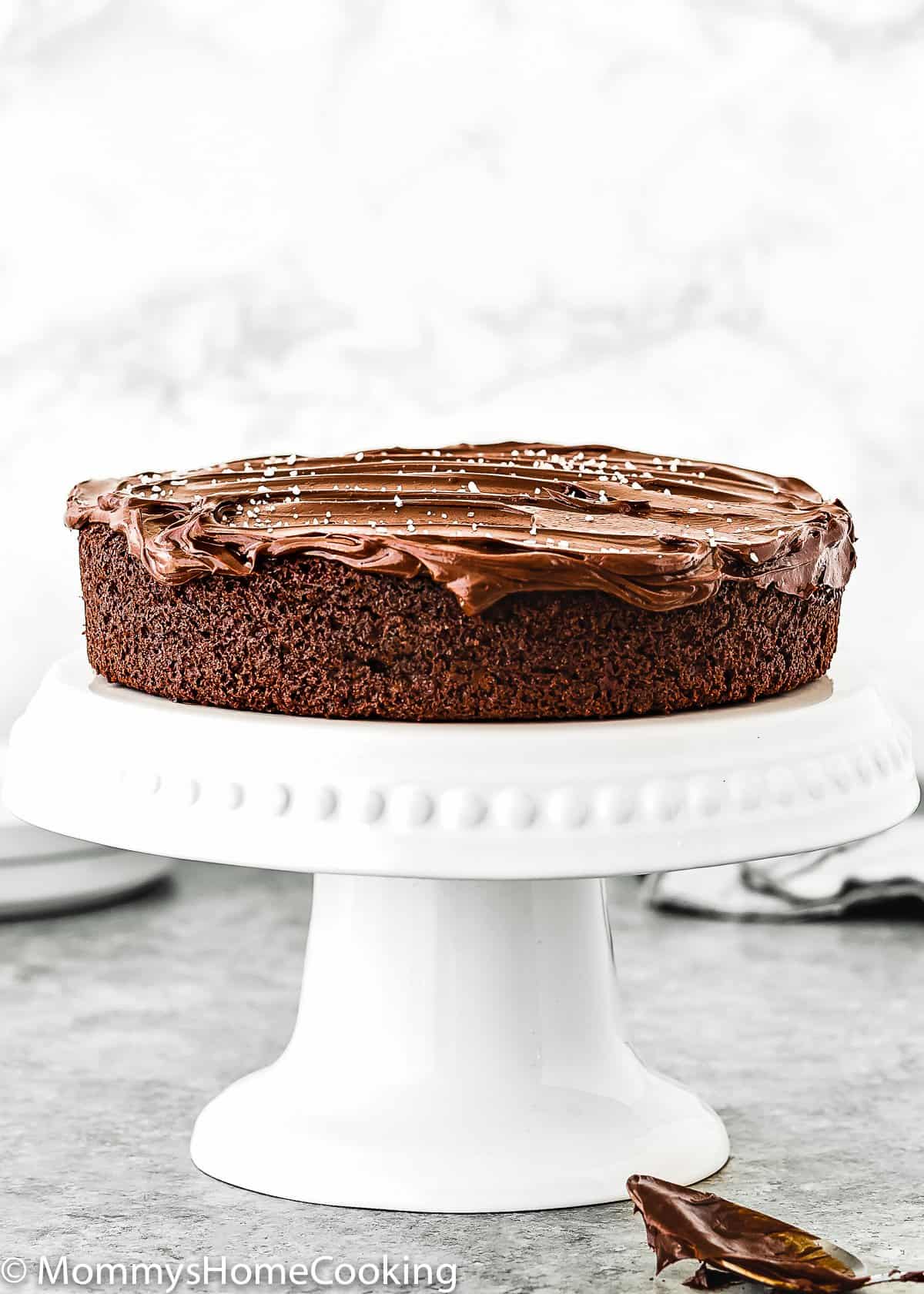 One Bowl Eggless Chocolate Cake on a cake stand with ganache frosting