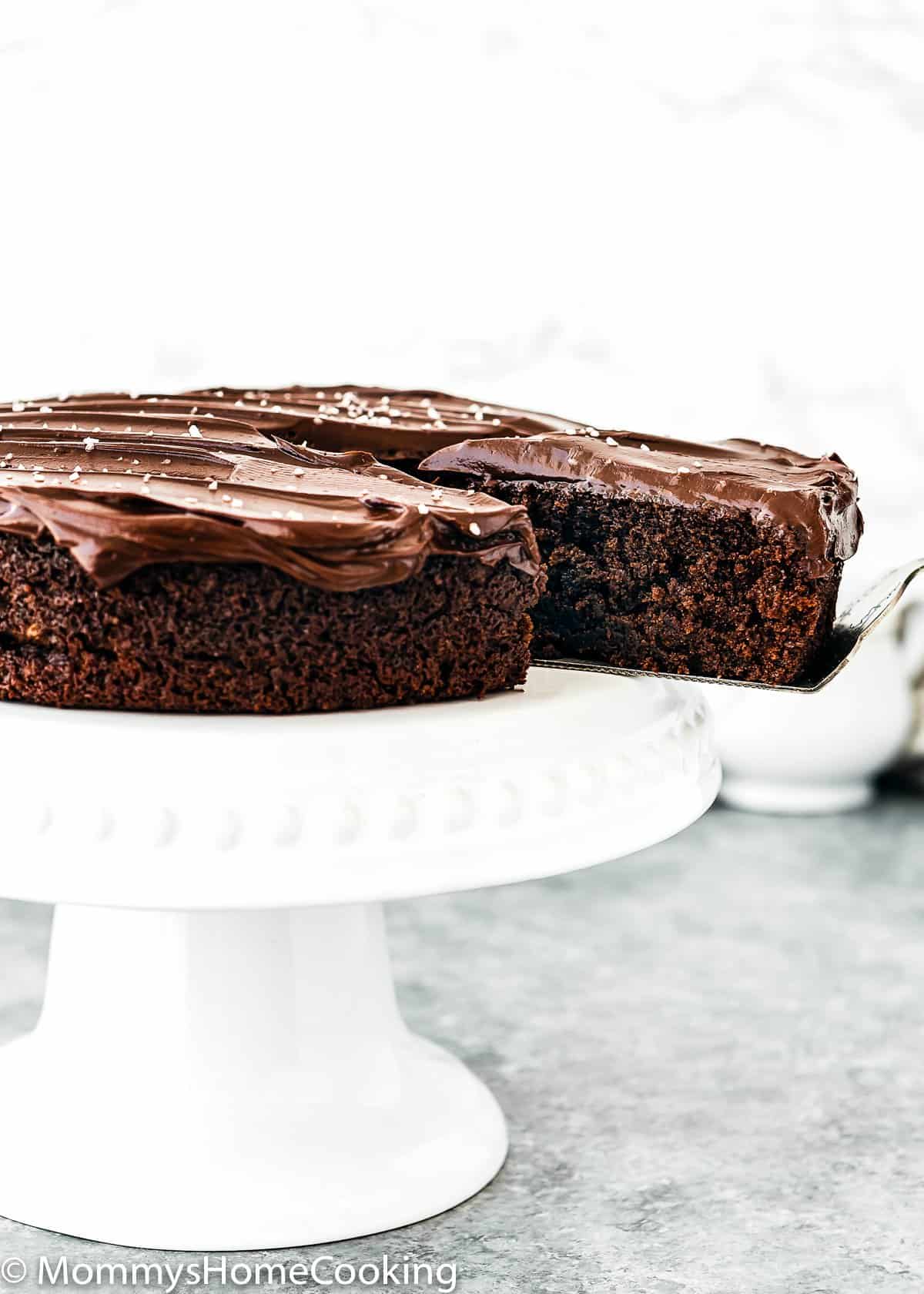 cake cutter holding a slice of One Bowl Eggless Chocolate Cake