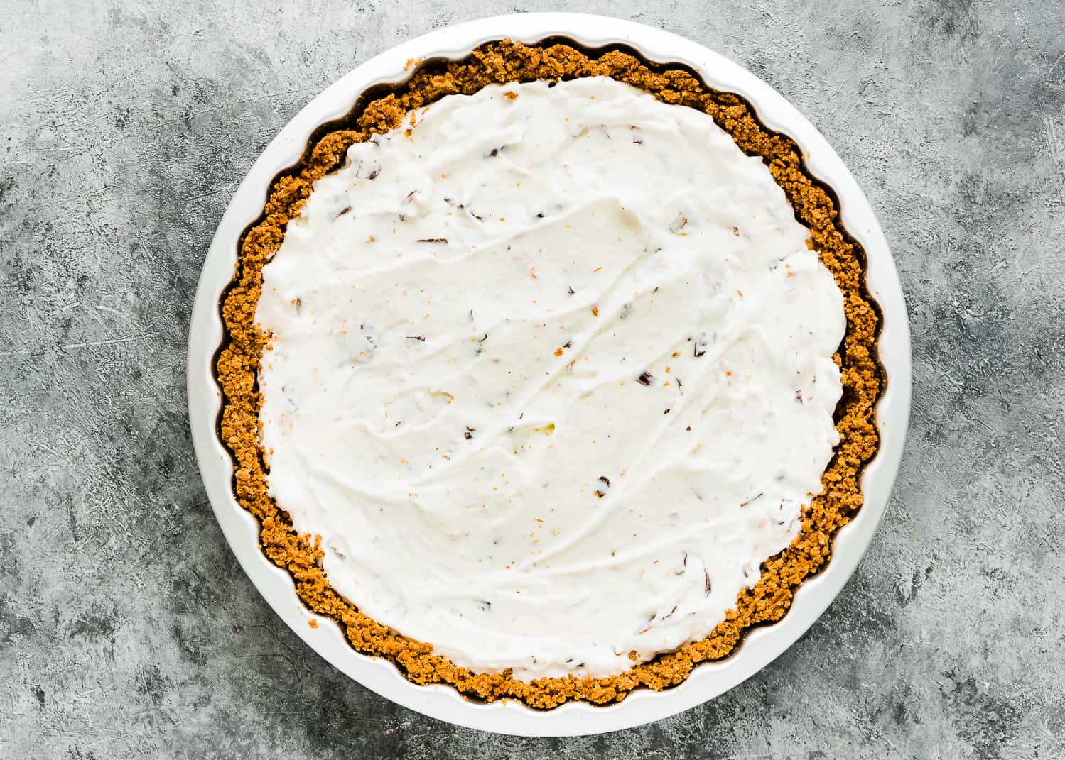 a ice cream cone crust filled with egg-free ice cream and candy bars in a pie dish. 