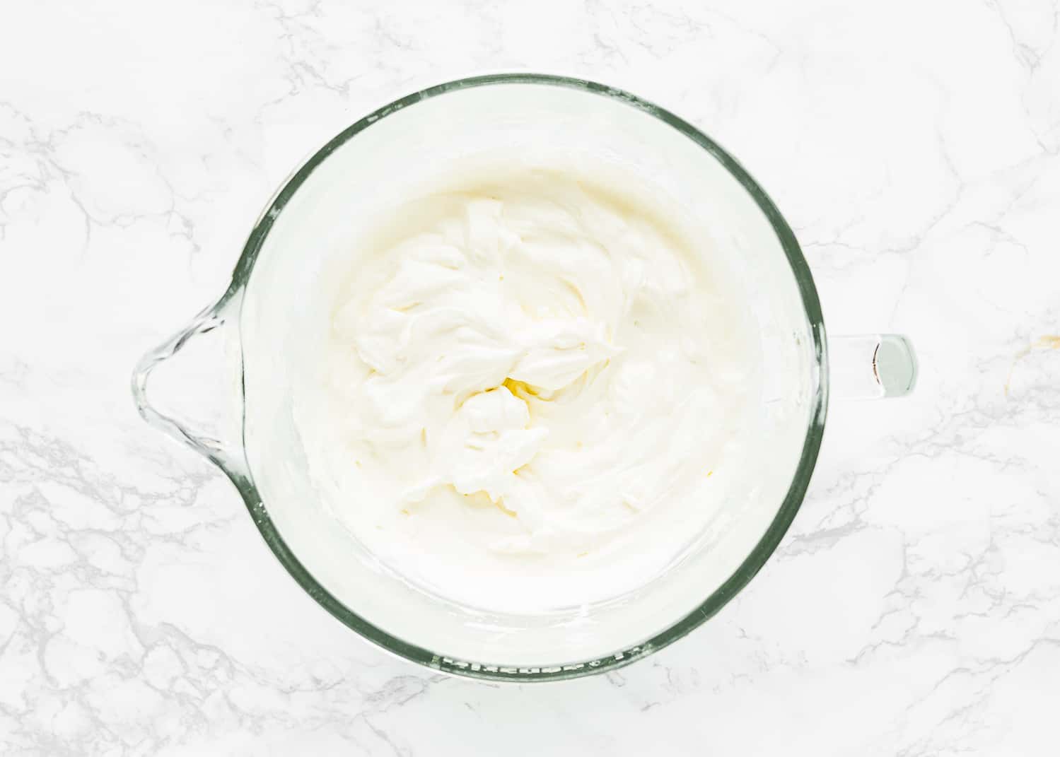 whipped cream in a bowl of a stand mixer. 