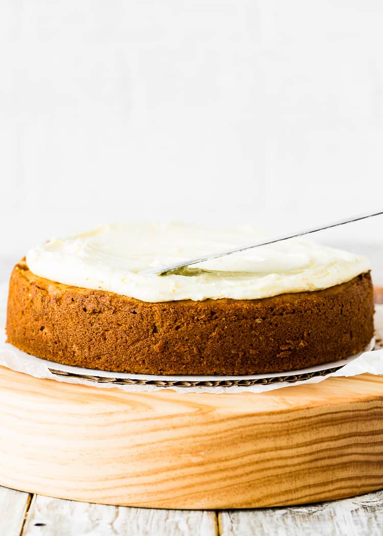 a spatula smoothing the buttercream over a egg-free cake. 