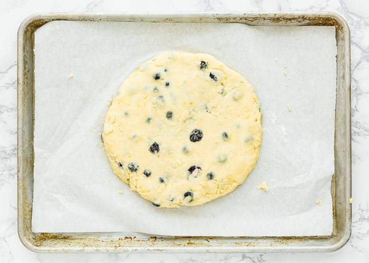 Eggless Blueberry Scones dough form into a disk over a baking tray. 