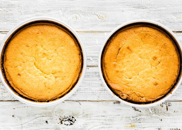 two cake pan with baked eggless orange cake.