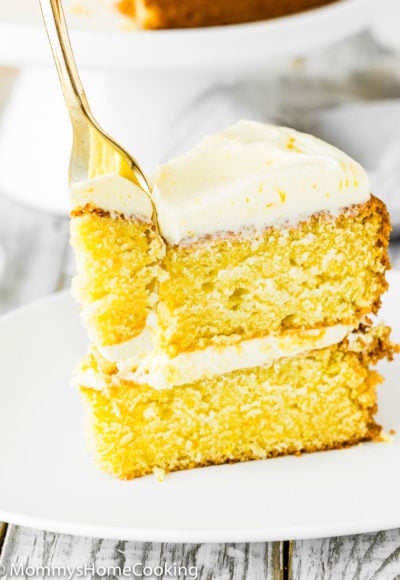 Eggless Orange Cake slice on a plate with a fork
