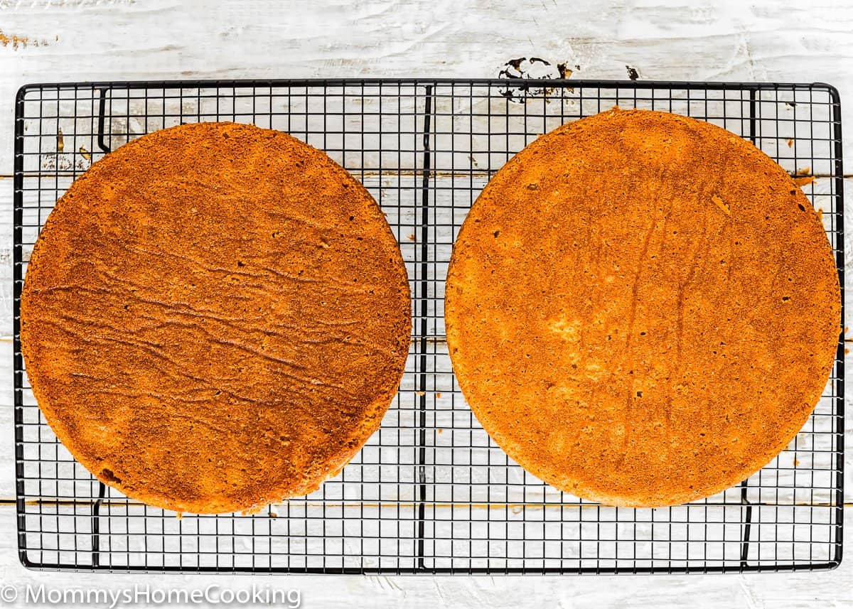 two layers of Eggless Orange Cake on a cooling rack