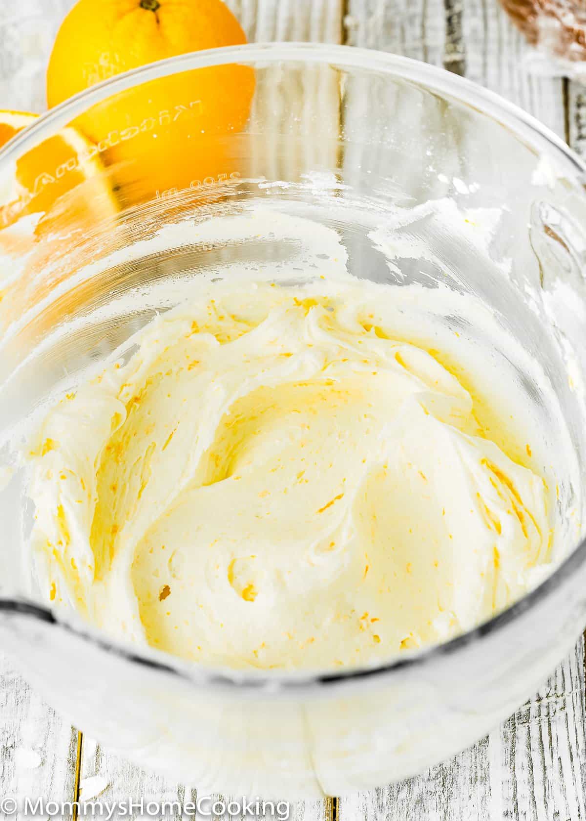orange buttercream in a glass bowl