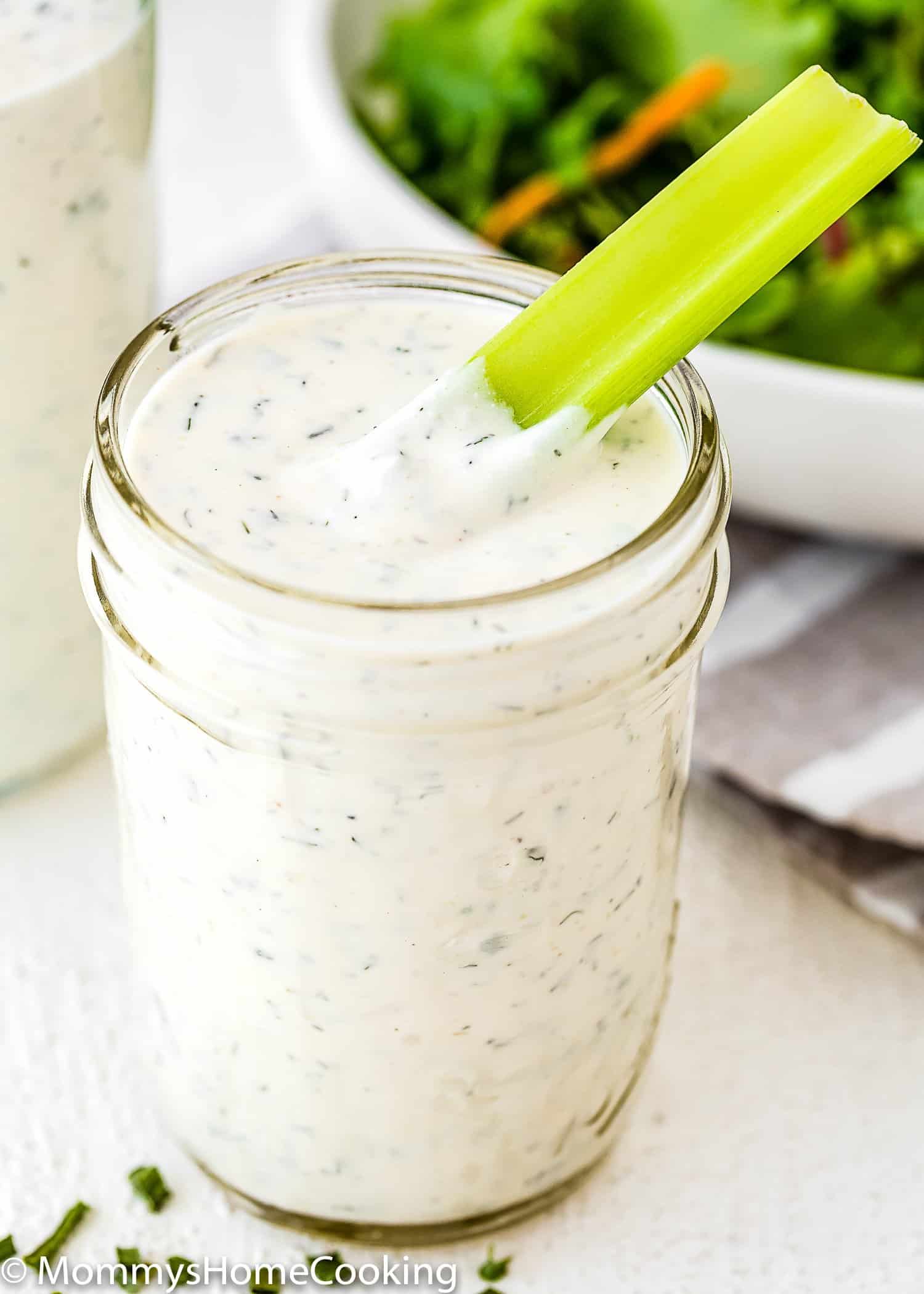 Homemade Eggless Ranch Dressing/sauce in a glass jar with a celery stick