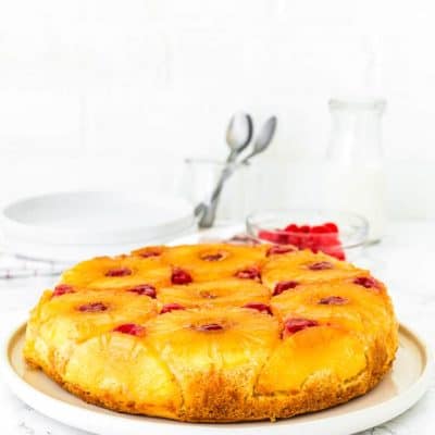 a whole Eggless Pineapple Upside Down Cake over a cake plate