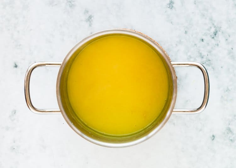 lemon curd being cooked in a small saucepan. 