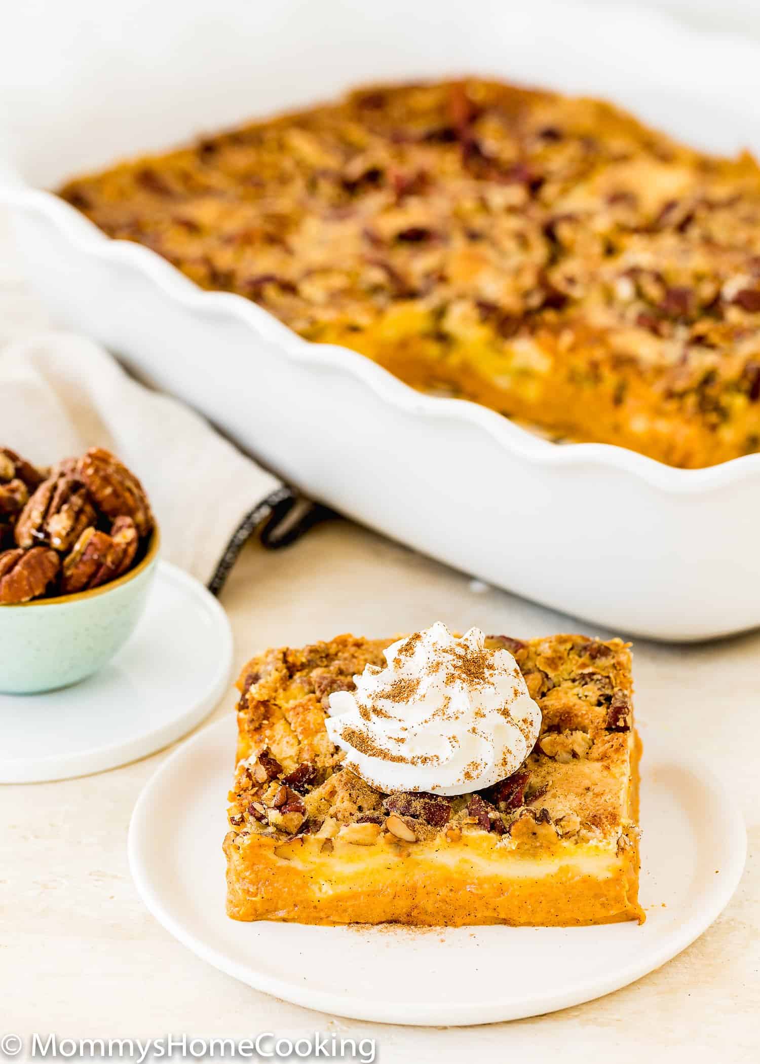 Easy Eggless Pumpkin Dump Cake with whipped cream on a plate.