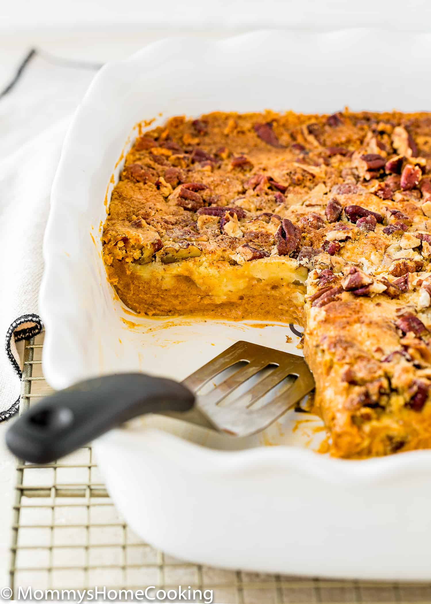 Egg-Free Pumpkin Dump Cake in a baking dish with a serving spatula.