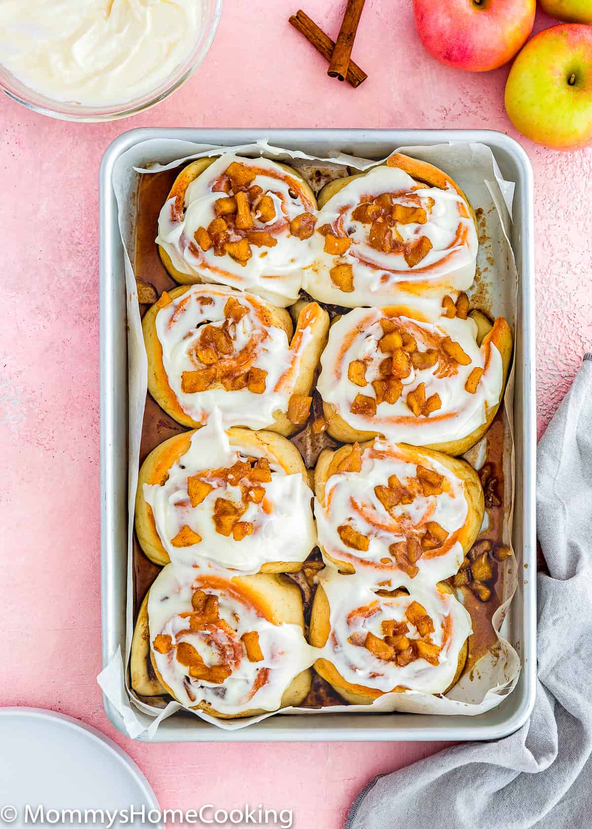 overhead view of Eggless Apple Cinnamon Rolls in a baking tray with glaze.
