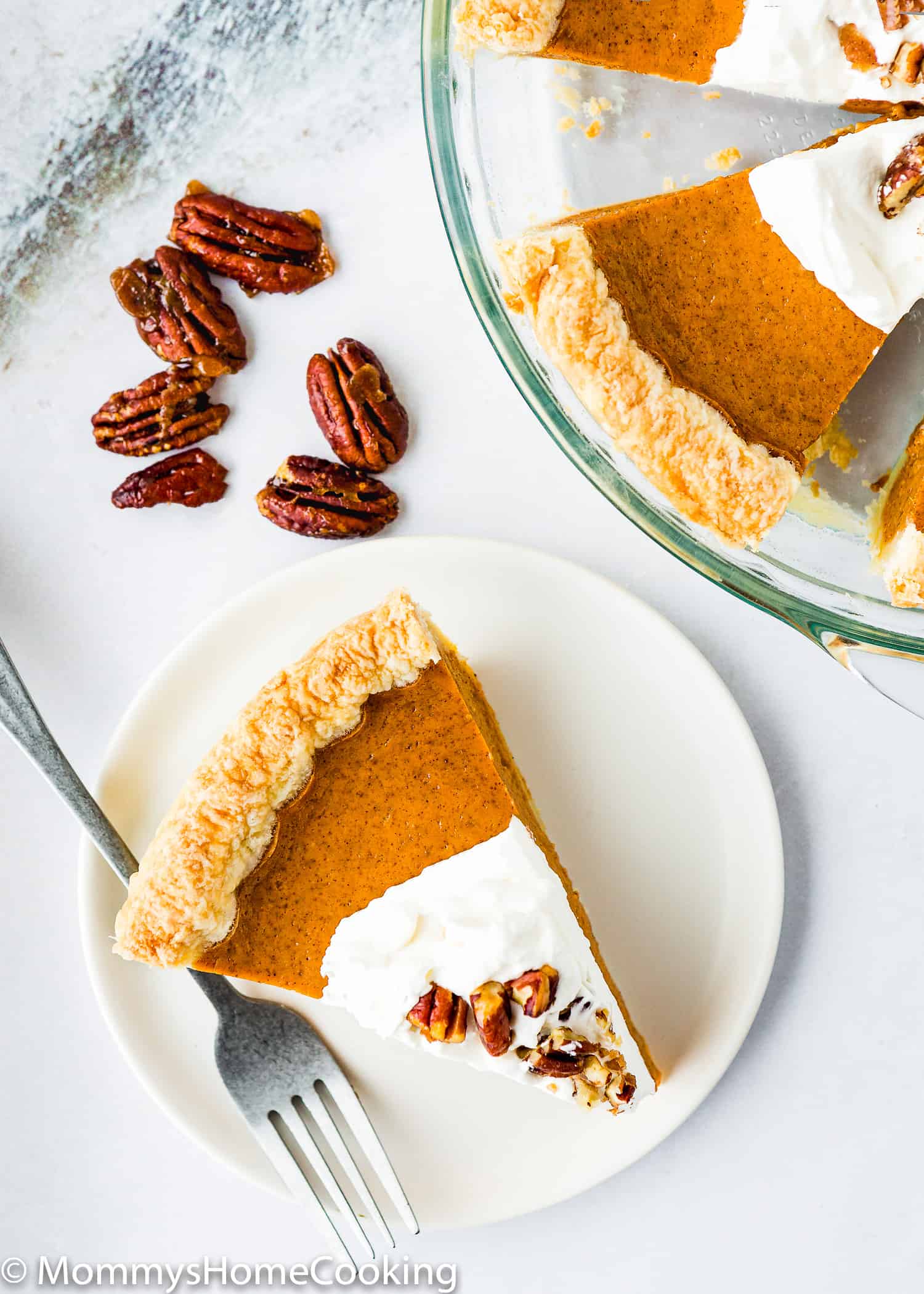 eggless sweet potato pie slice with whipped cream and candied pecans in a plate.