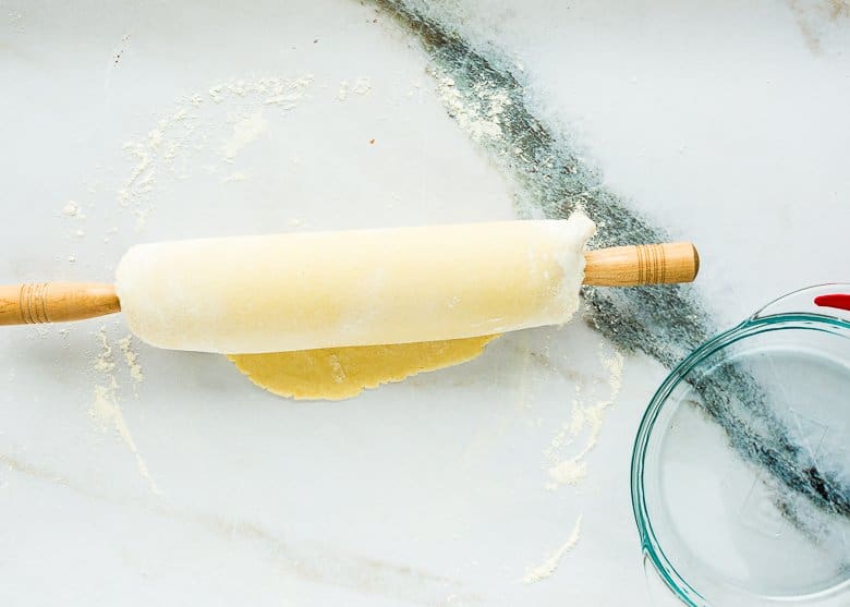 rolled out pie dough wrapped in a rolling pin.