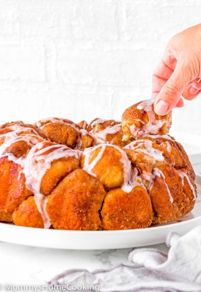 a hand taking a piece of Homemade Eggless Monkey Bread