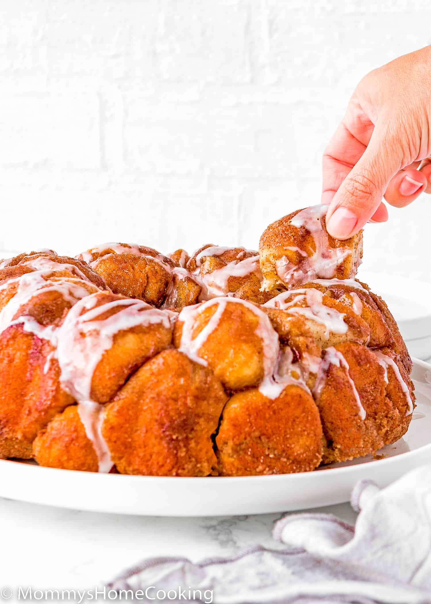 a hand taking a piece of Homemade Eggless Monkey Bread