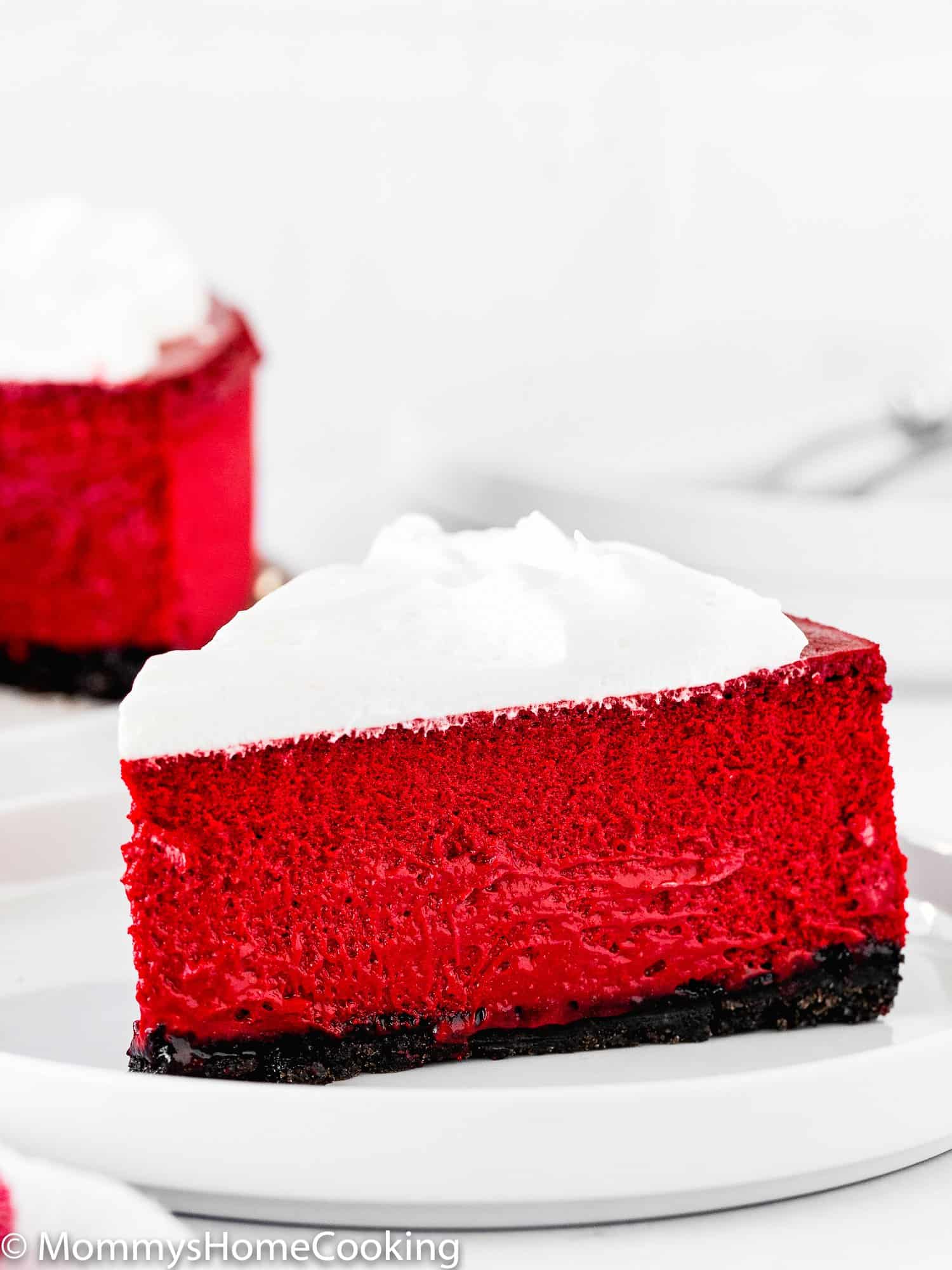 a slice of eggless red velvet cheesecake with whipped cream.