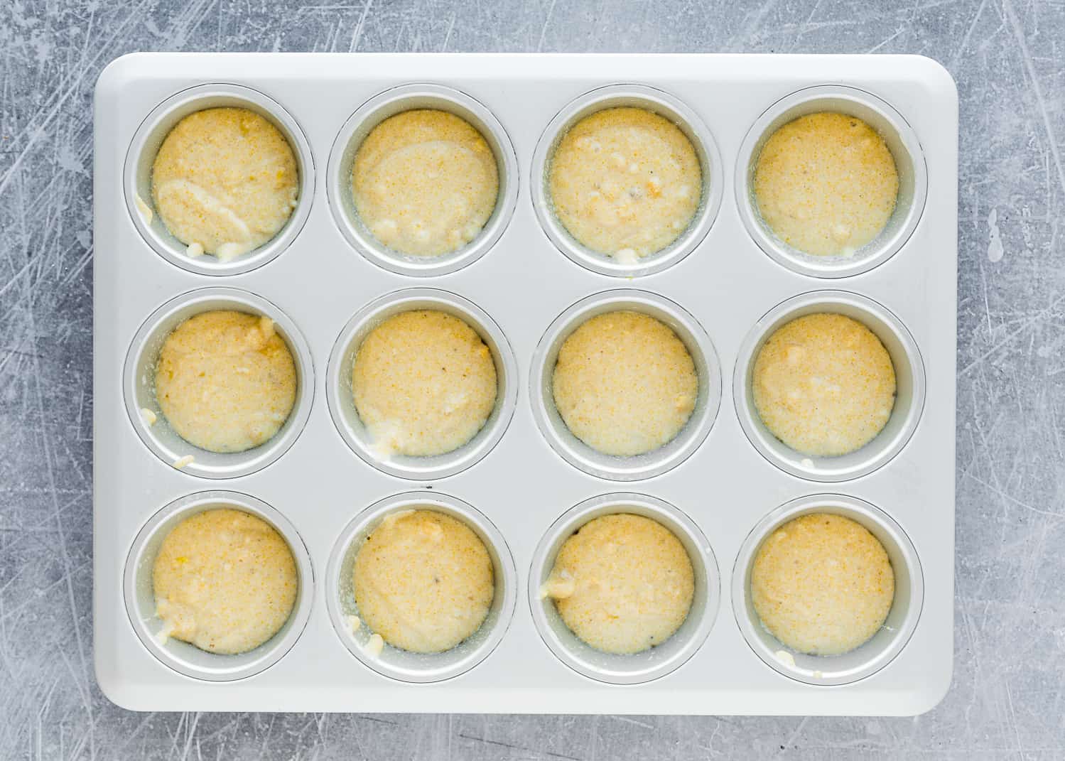 Eggless Cornbread Muffins batter in a muffin pan.