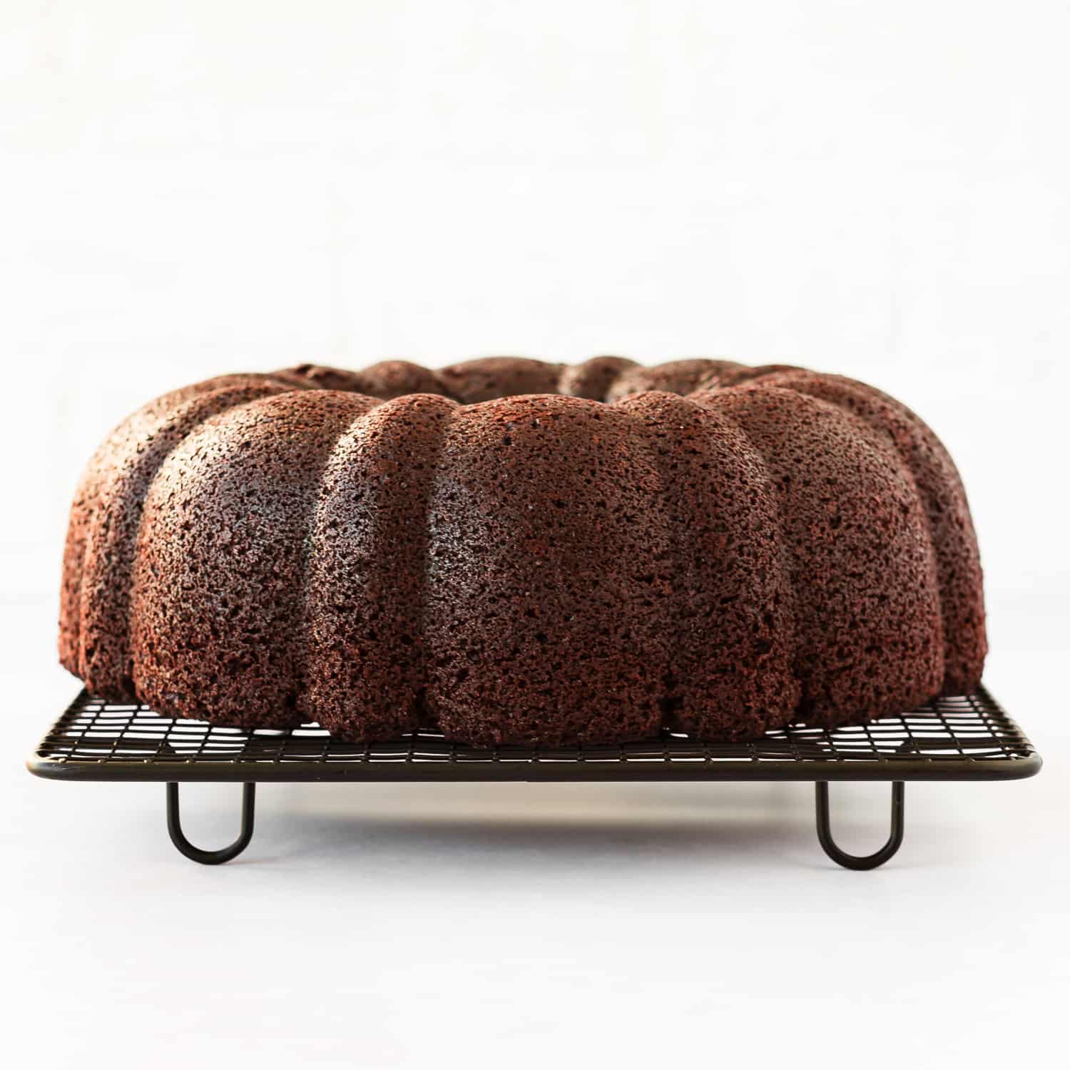 baked Eggless Chocolate Bundt cake over a cooling rack.