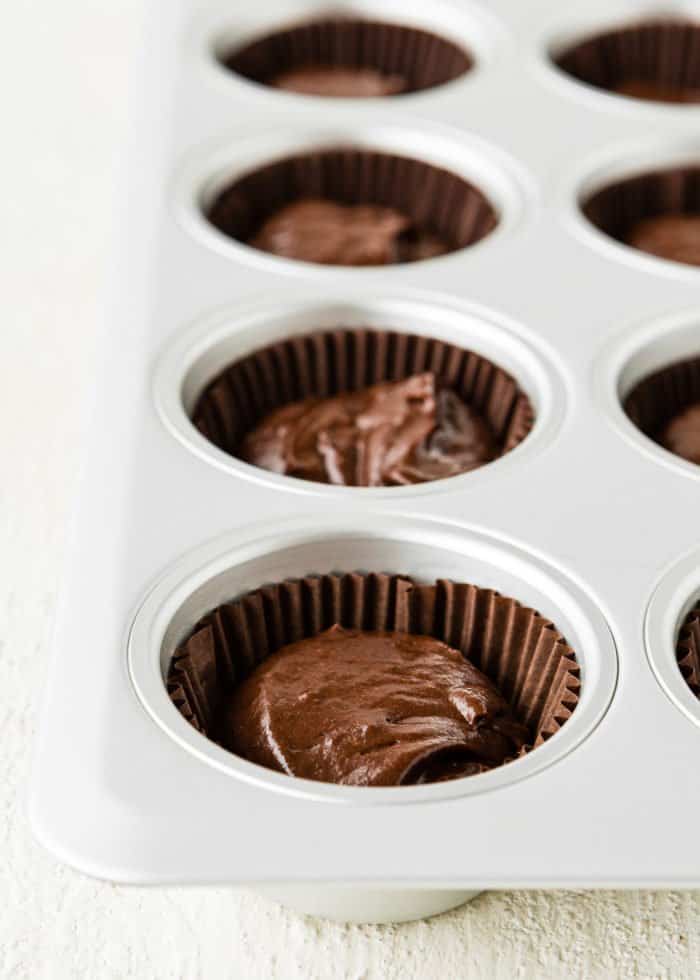 cupcakes liners in a cupcake pan filled with eggless chocolate cupcake batter. 
