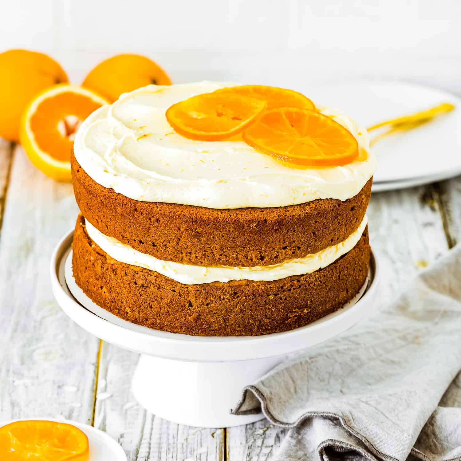 two layer egg-free orange cake on a cake stand.