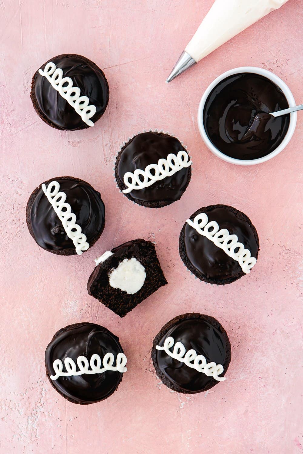 egg-free homemade hostess cupcakes over a pink surface. 