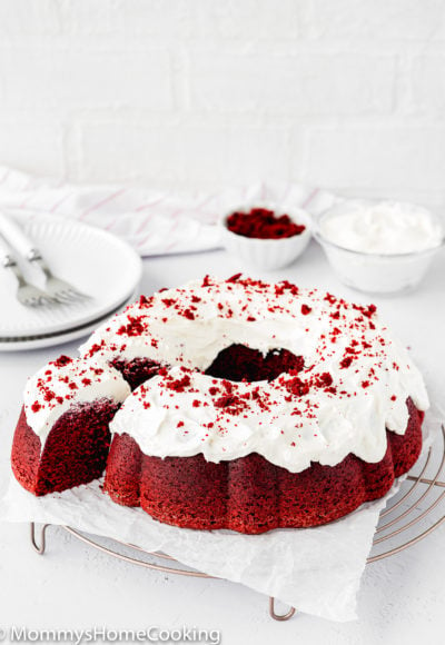 Eggless Red Velvet Bundt Cake with cream cheese frosting over a cooling rack